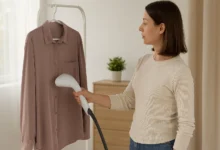 یک خانم در حال استفاده از بخارگر دستی برای اتو کردن لباس
