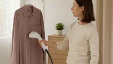 یک خانم در حال استفاده از بخارگر دستی برای اتو کردن لباس